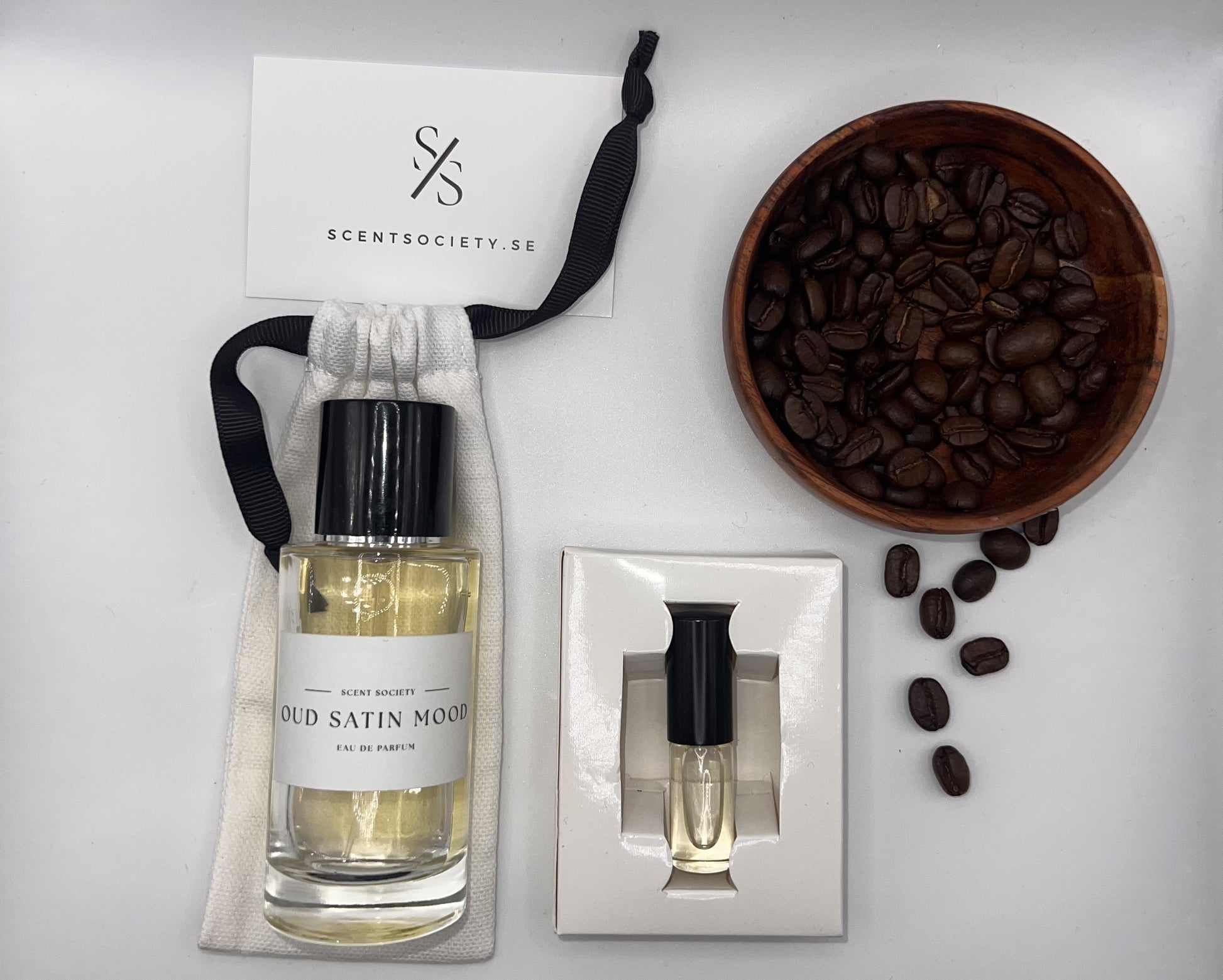 Perfume bottle and gift set with coffee beans representing rich cherry and spicy notes of Oud Rose fragrance by ScentSociety