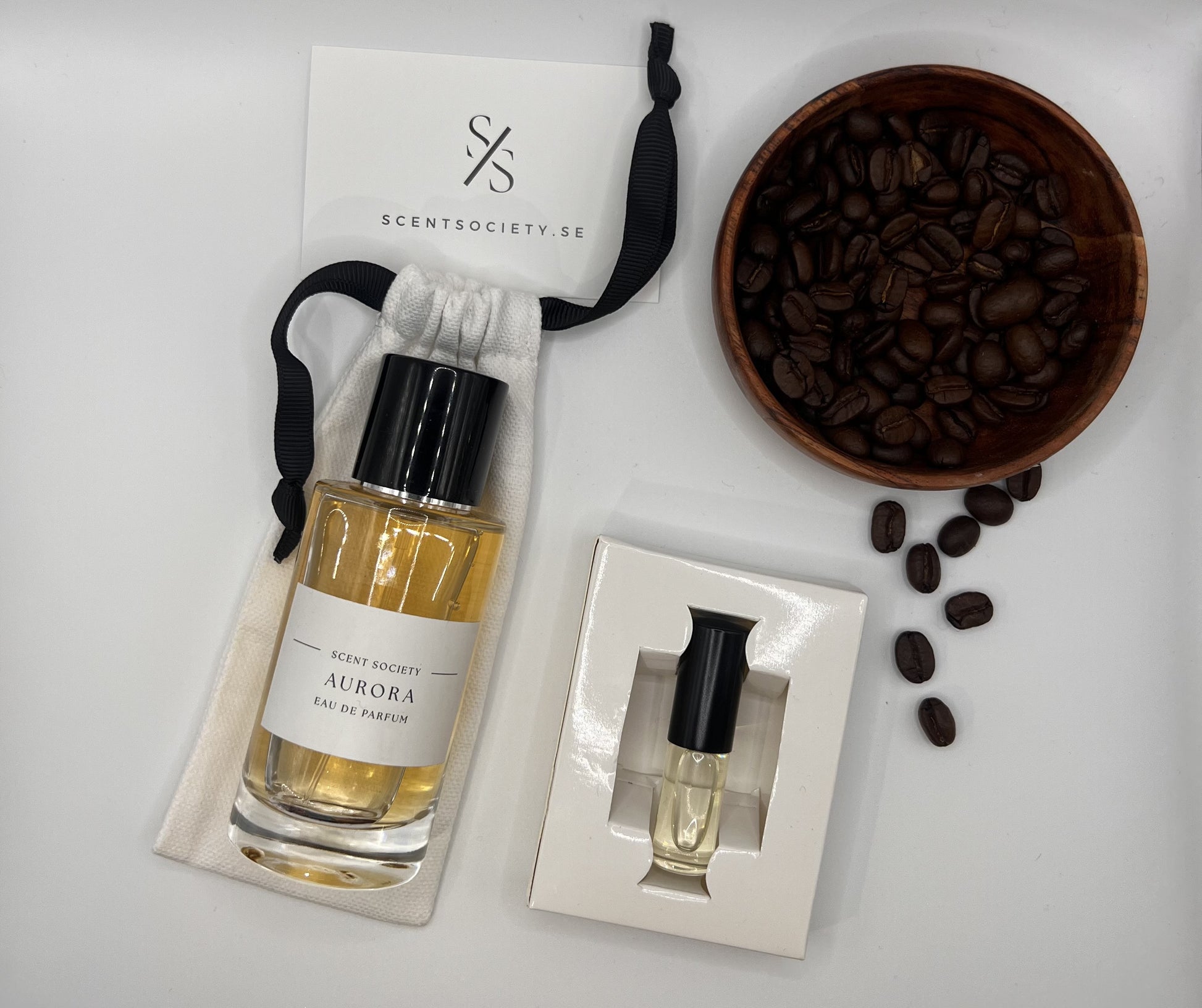 Perfume bottle and gift set with coffee beans representing rich cherry and spicy notes of Aurora fragrance by ScentSociety