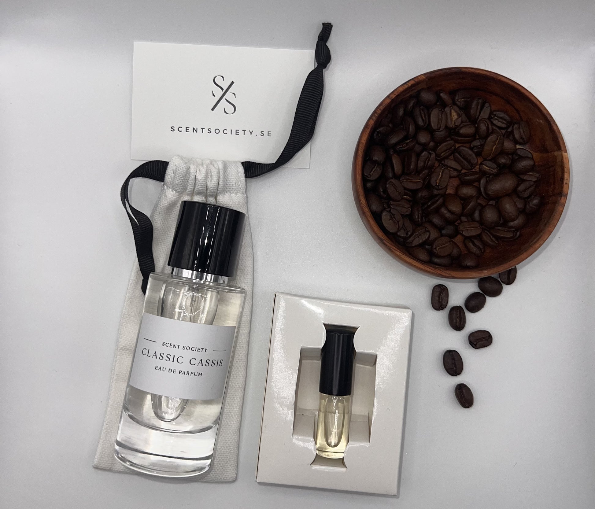 Perfume bottle and gift set with coffee beans representing rich cherry and spicy notes of Classic Cassis fragrance by ScentSociety