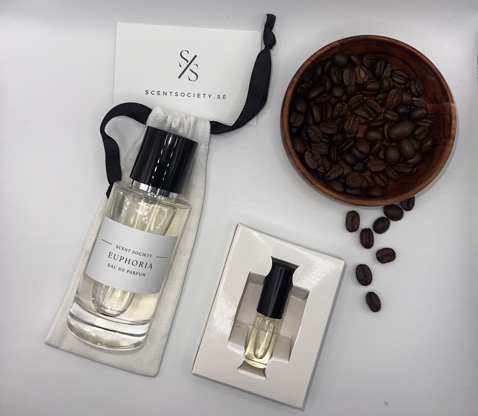 Perfume bottle and gift set with coffee beans representing rich cherry and spicy notes of Euphoria fragrance by ScentSociety