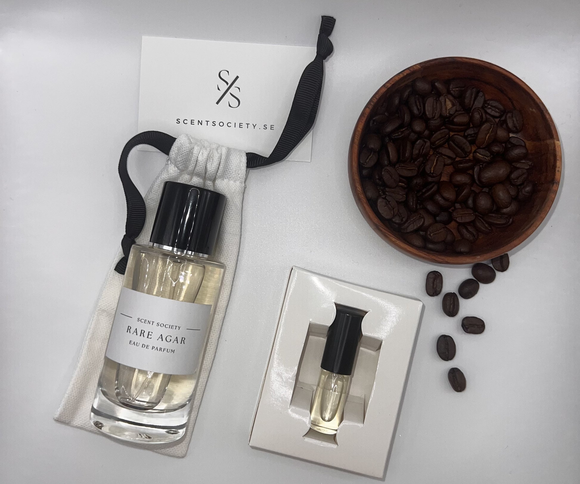 Perfume bottle and gift set with coffee beans representing rich cherry and spicy notes of Rare Agar fragrance by ScentSociety