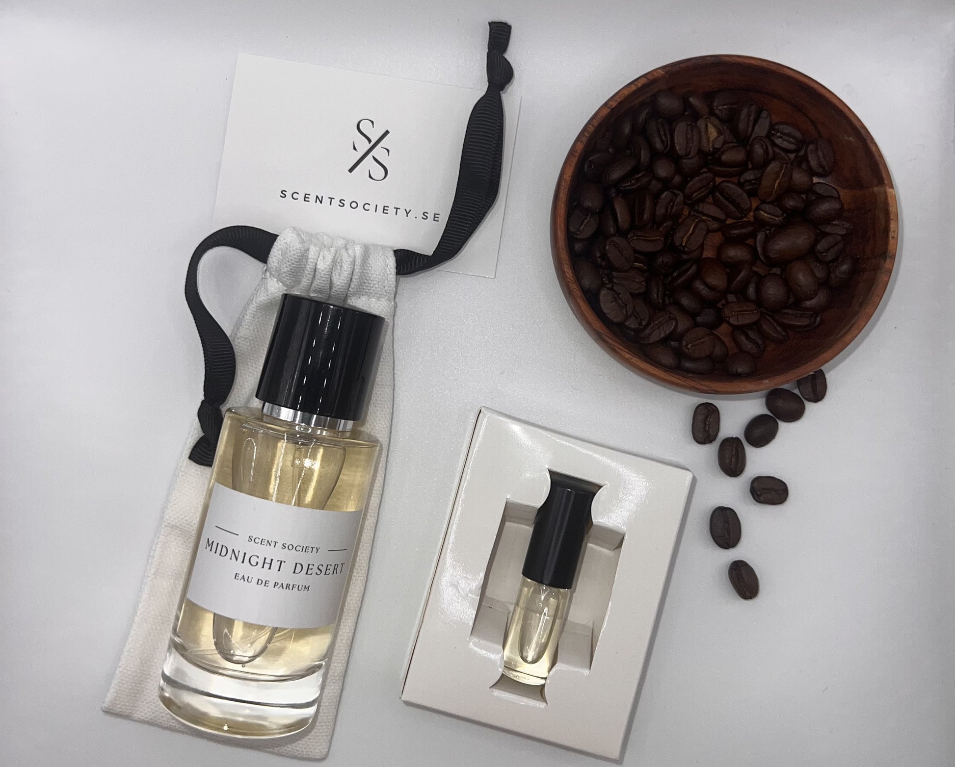 Perfume bottle and gift set with coffee beans representing rich cherry and spicy notes of Midnight Dessert fragrance by ScentSociety
