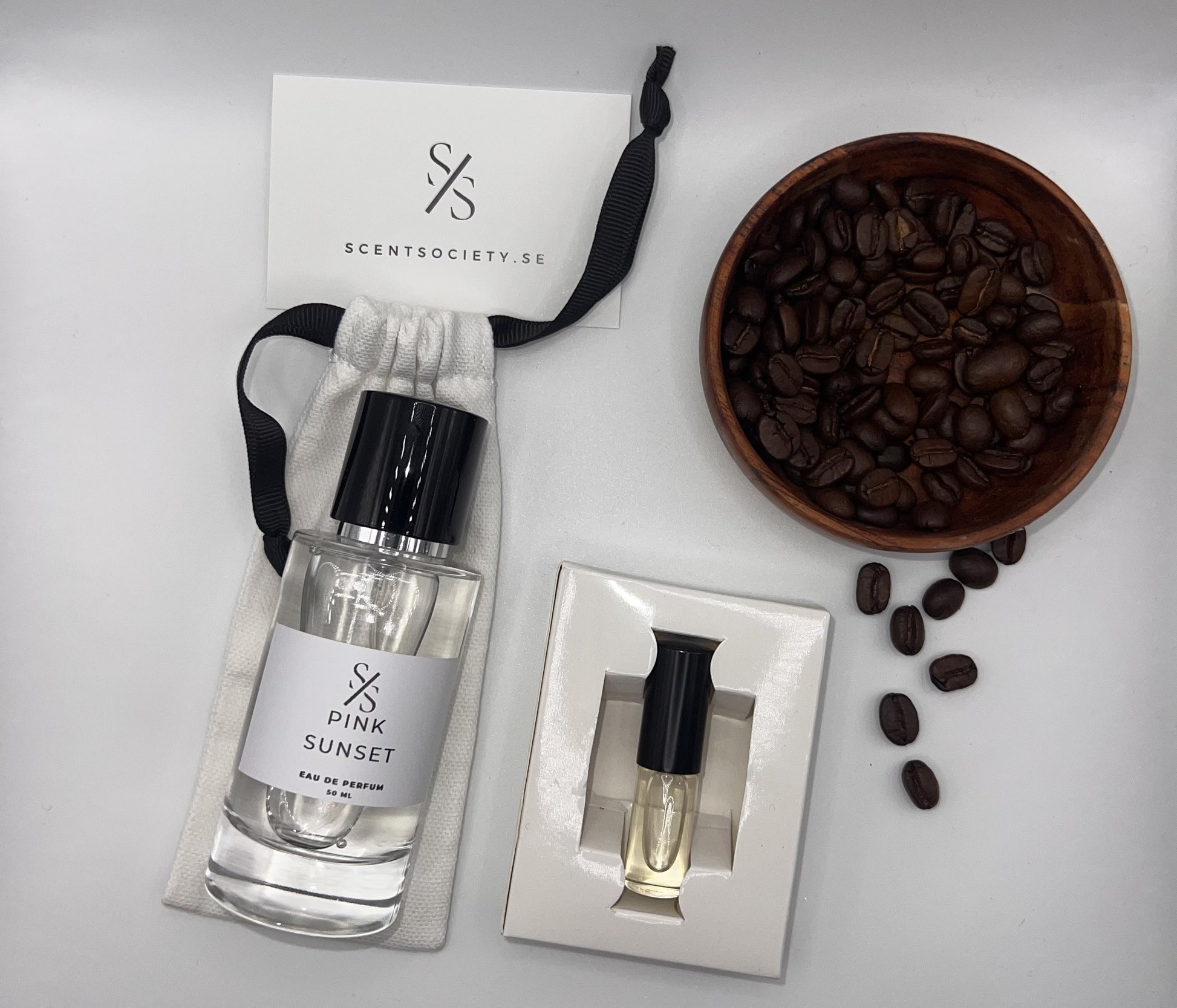 Perfume bottle and gift set with coffee beans representing rich cherry and spicy notes of Pink Sunset fragrance by ScentSociety