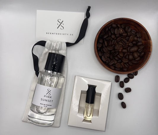 Perfume bottle and gift set with coffee beans representing rich cherry and spicy notes of Pink Sunset fragrance by ScentSociety