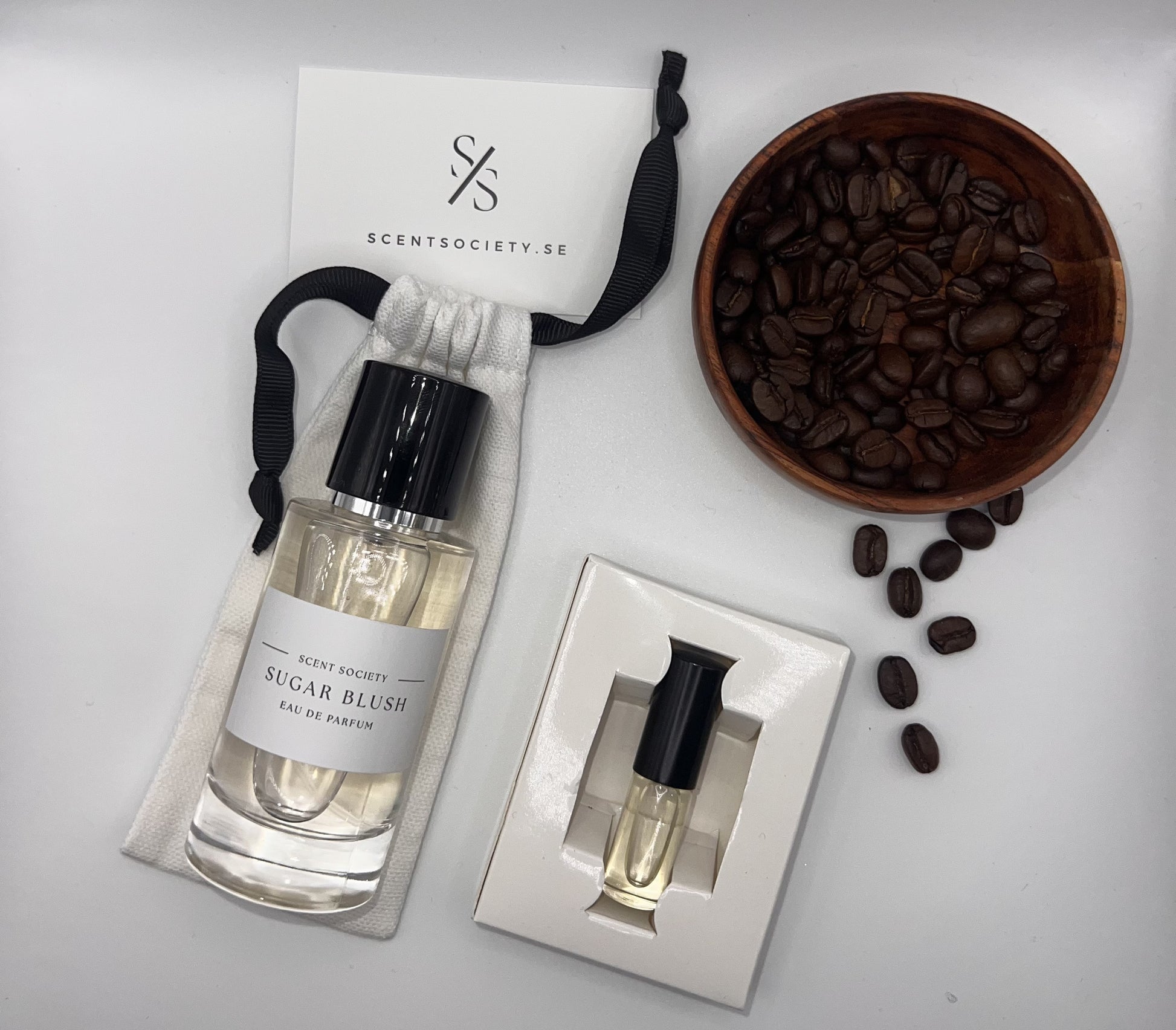 Perfume bottle and gift set with coffee beans representing rich cherry and spicy notes of Sugar Blush fragrance by ScentSociety